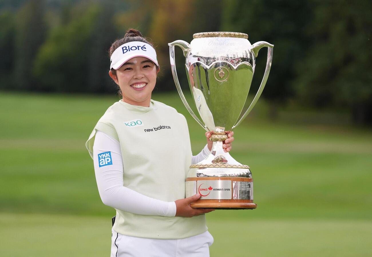 ゴルフのCPKC女子オープンで優勝し、トロフィーを掲げる山下美夢有。今季2勝目、ツアー通算4勝目を挙げた＝23日、カナダ・エドモントンのロイヤル・メイフェアGC（共同）