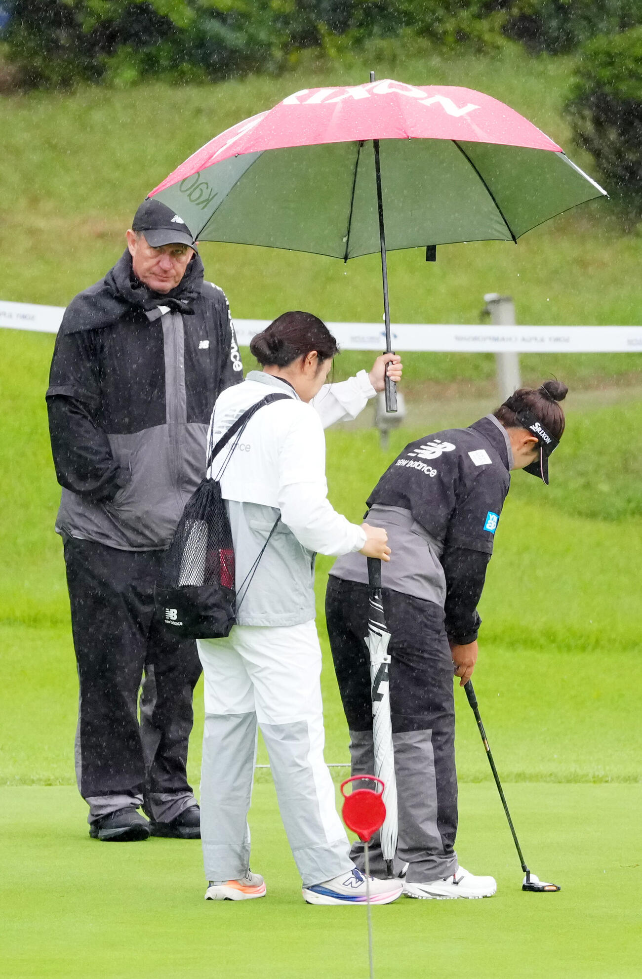 雨の中、パット練習する山下美夢有（右）（撮影・江口和貴）