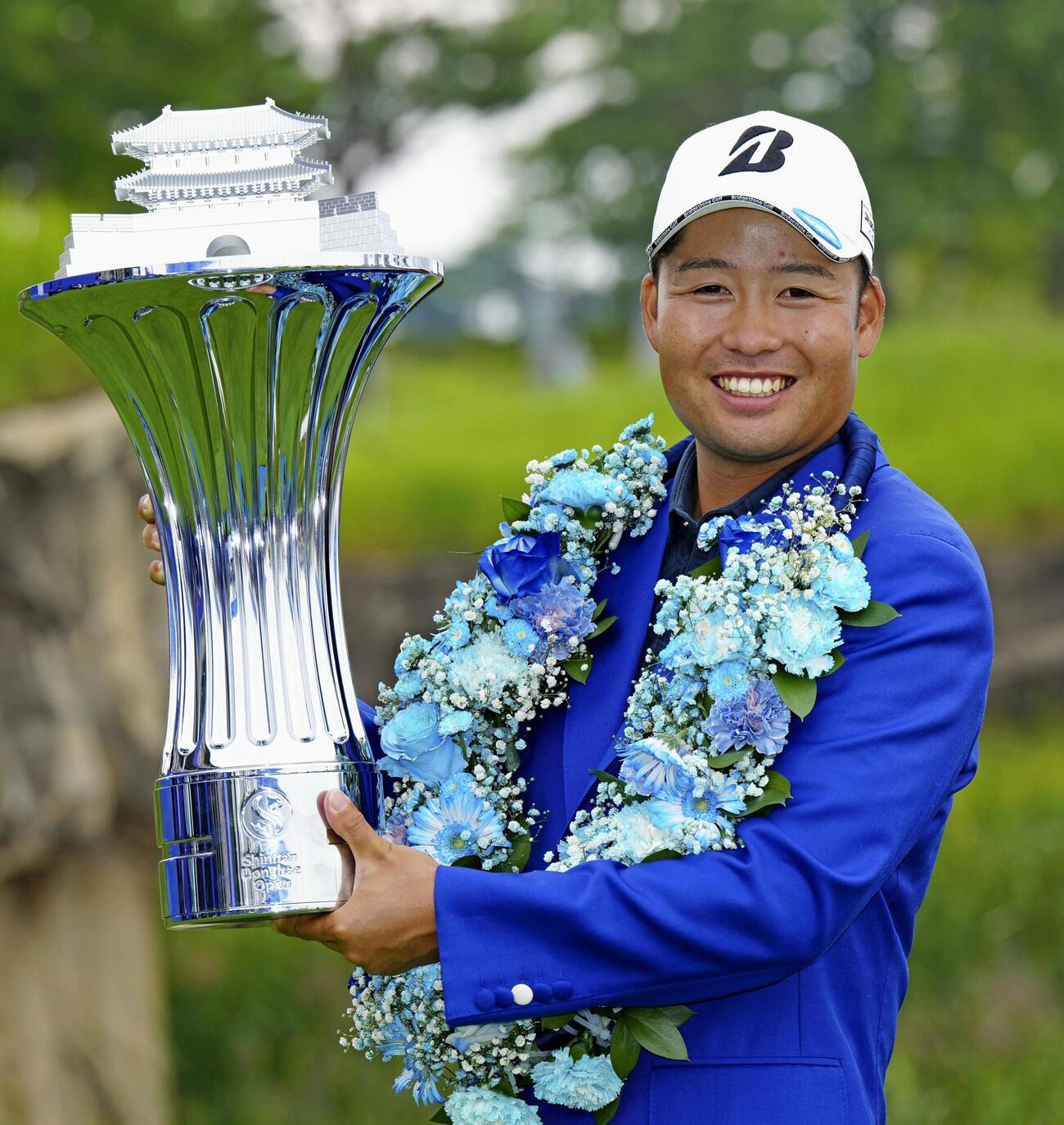 通算16アンダーで初優勝し、トロフィーを手に笑顔の砂川公佑（共同）