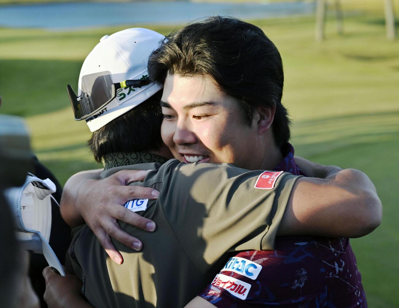 通算13アンダーで優勝し、2位の坂本雄介（左）から祝福される細野勇策（共同）