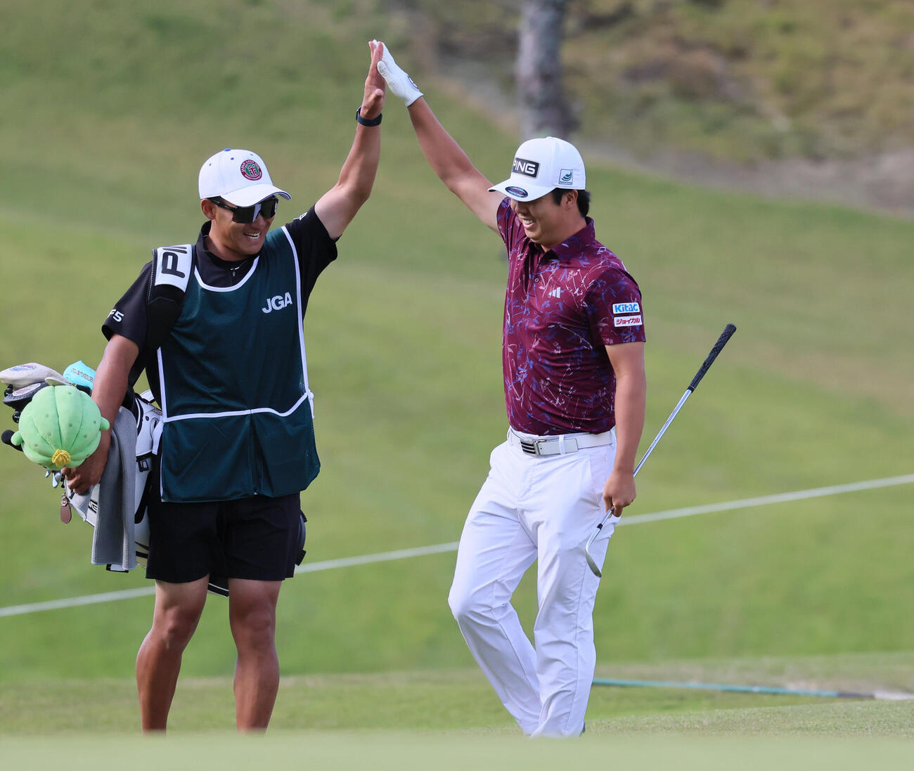 日本オープンゴルフ最終日、8番、チップインバーディーを決めてハイタッチする細野勇策（撮影・宮崎幸一）