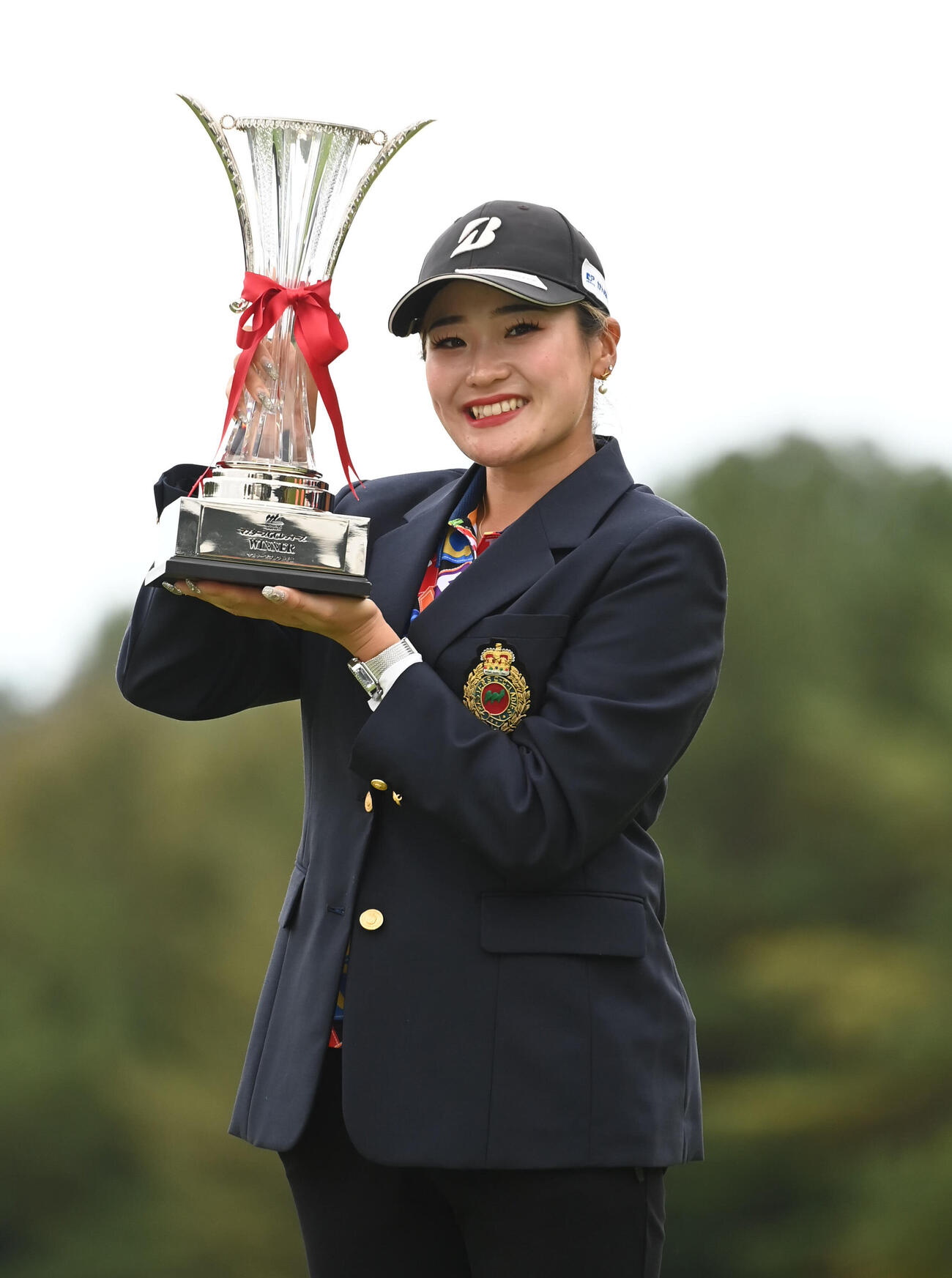優勝カップを手に笑顔を見せる桑木志帆（撮影・石井愛子）