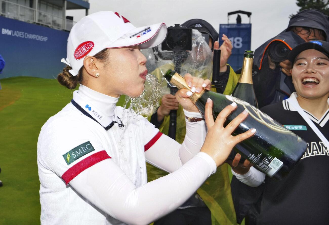 最終ラウンド、通算17アンダーで米ツアー初優勝を果たし、シャンパンを飲む吉田優利＝パインビーチ・リンクス（共同）