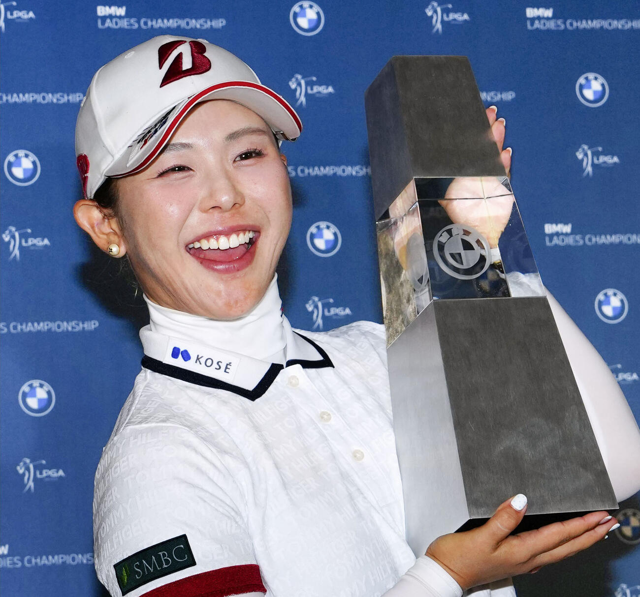 最終ラウンド、通算17アンダーで米ツアー初優勝を果たし、トロフィーを手に笑顔を見せる吉田優利＝パインビーチ・リンクス（共同）
