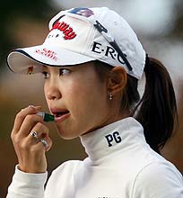 寒風が吹くラウンド中、リップクリームを塗る上田桃子