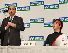 ヨネックス米山社長(左)の隣でホコリを吹き飛ばすようなしぐさをする石川遼