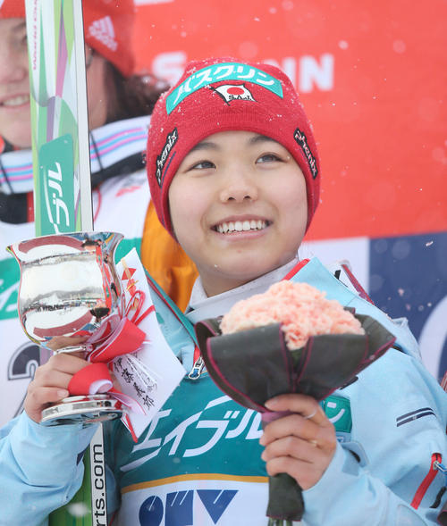 逆転優勝を果たし笑顔でカップと花束を持つ高梨（１５年１月１１日）（撮影・井上学）