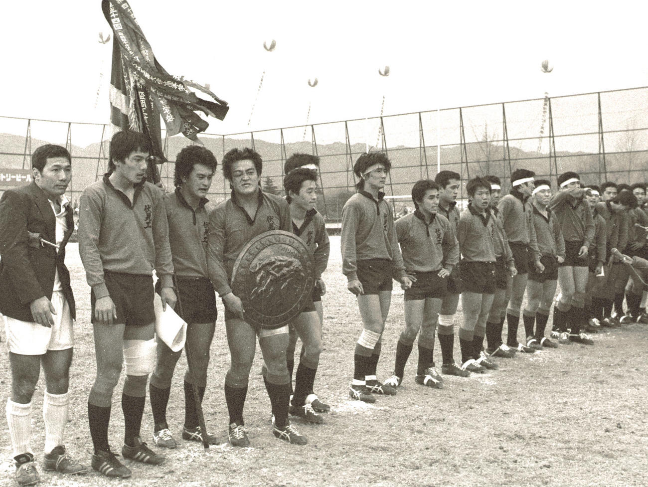 １９８１年１月７日、決勝戦で大工大高を破り優勝を飾り、表彰を受ける伏見工フィフティーン。左から２人目は平尾誠二さん