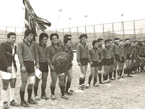１９８１年１月７日、決勝戦で大工大高を破り優勝を飾り、表彰を受ける伏見工フィフティーン。左から２人目は平尾誠二さん