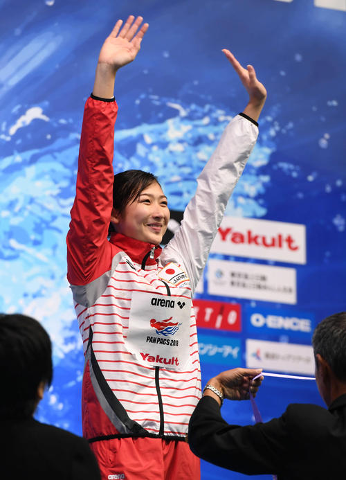 女子１００メートルバタフライ　金メダルを獲得した池江は表彰式で笑顔を見せて声援に応える（撮影・山崎安昭）