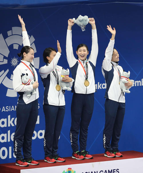 女子400メートルメドレーリレーで優勝し表彰式でマスコット人形を高く掲げる池江（左から3人目）。左から酒井、鈴木、1人おいて青木（撮影・河野匠）2018年8月23日