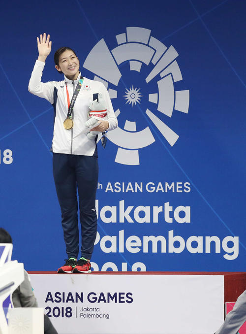 女子100メートルバタフライで優勝し表彰式で笑顔を見せる池江（撮影・河野匠）＝2018年8月21日