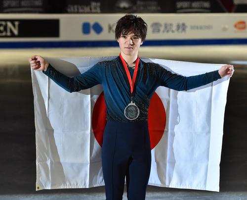 グランブリファイナルで2位に入り、銀メダルを首にかけ、日の丸を掲げる宇野(撮影・菅敏)