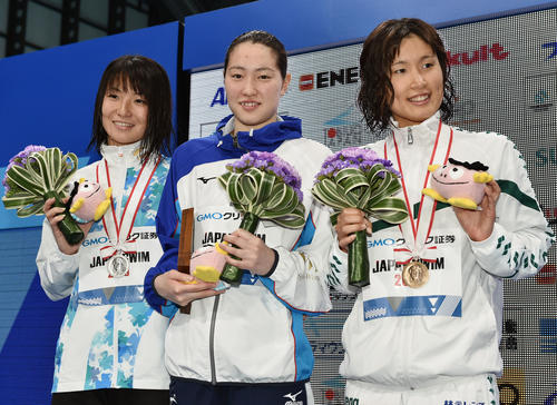 女子50メートル背泳ぎで優勝し記念撮影する酒井（中央）。左は2位の竹村。右は3位の高橋（撮影・滝沢徹郎）