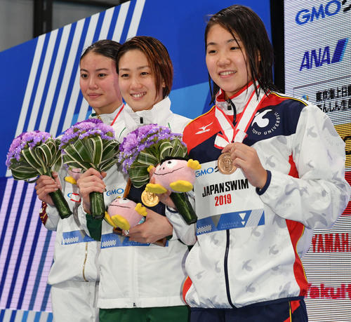 女子100メートル自由型で優勝し記念撮影する青木（中央）。左は2位の大本。右は3位の白井（撮影・滝沢徹郎）