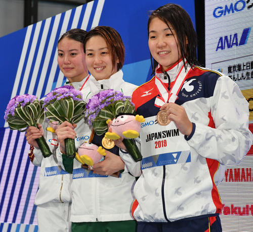 女子100メートル自由型で優勝し記念撮影する青木(中央)。左は2位の大本。右は3位の白井(撮影・滝沢徹郎)