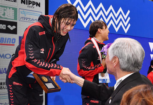 女子200メートルバタフライで優勝し表彰式で笑顔の長谷川(左)(撮影・滝沢徹郎)