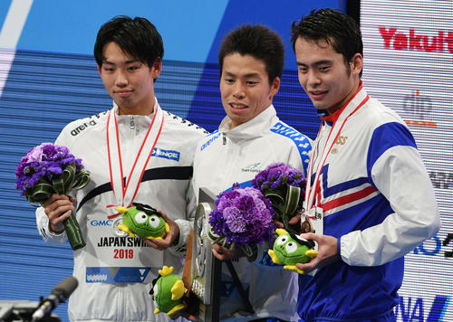 男子1500メートル自由型で優勝し記念撮影する平井（中央）。左は2位の竹田。右は3位の仲家（撮影・滝沢徹郎）