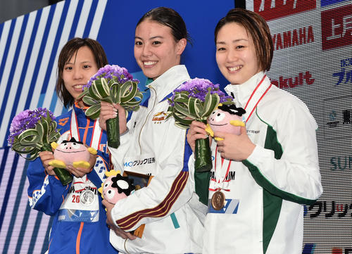 女子50メートル自由型で優勝し表彰式で記念撮影する大本（中央）。左は2位の佐藤。右は3位の青木（撮影・滝沢徹郎）