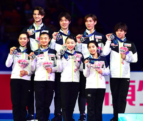 表彰式でメダルを掲げる2位の日本チーム、前列から小松原美里、坂本花織、紀平梨花、三浦璃来、後列左からティム・コレト、市橋翔哉、田中刑事、宇野昌磨（撮影・清水貴仁）
