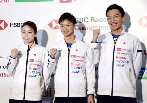 ジャパン・オープンの記者会見後にポーズをとる桃田賢斗（右）と渡辺（中央）、東野組）（共同）