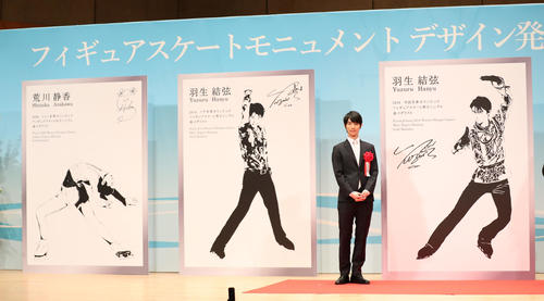 新たなモニュメントのデザイン画（右）や荒川静香さんのデザイン画（左）とともに記念撮影におさまる羽生結弦（撮影・林敏行）