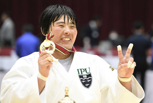 連覇を達成した素根はメダルを手に笑顔を見せる（撮影・鈴木みどり）