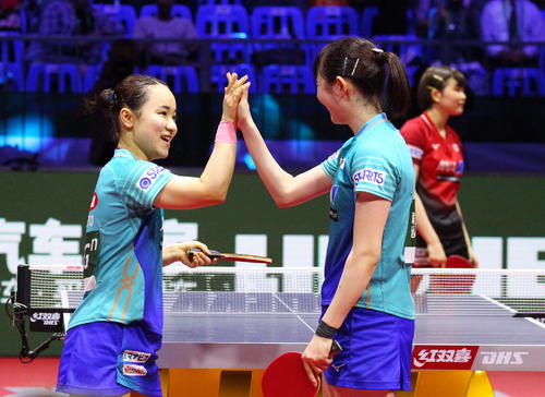 女子ダブルスの日本人対決を制し、決勝進出を決めハイタッチする伊藤美誠（左）と早田ひな。奧は橋本帆乃香（撮影・三須一紀）
