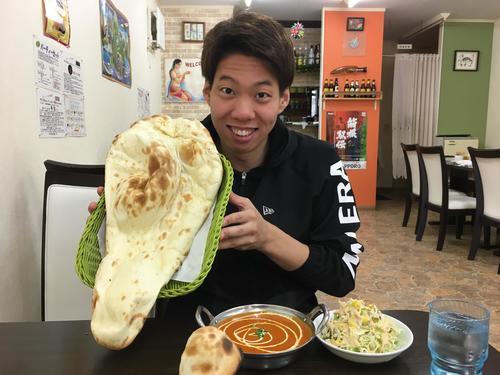 午前練習を終えて、昼食で顔の2倍以上あるナンを手にする競泳渡辺