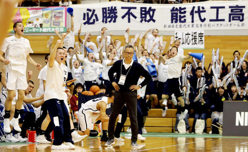 能代工対開志国際　シュートが決まり盛り上がる能代工の選手たちと、ベンチ前からプレーを見つめる小野HC（撮影・野上伸悟）