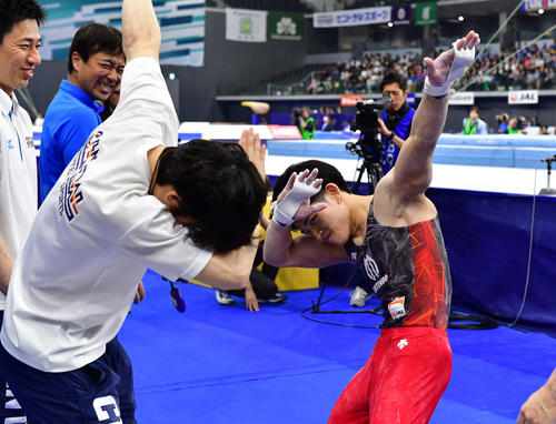 最終種目の鉄棒を終え、ポーズを決める谷川翔（右）（撮影・鈴木みどり）