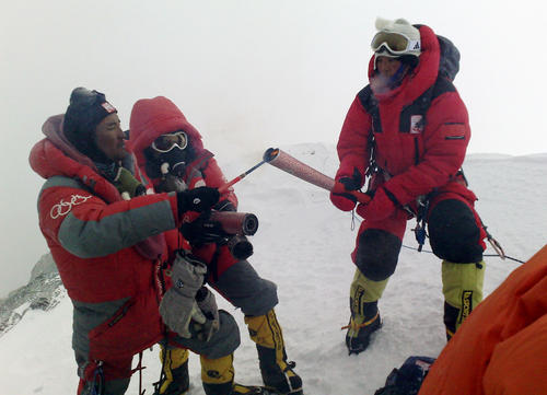 08年5月、チョモランマの頂上直下で北京五輪聖火の火種からトーチに点火する登山隊員（新華社＝共同）