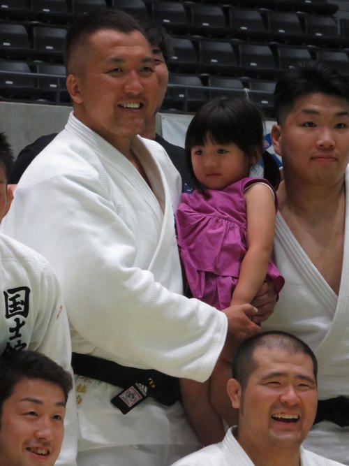 表彰式後、長女の楓子ちゃんを抱いて記念撮影する鈴木桂治氏（撮影・峯岸佑樹）