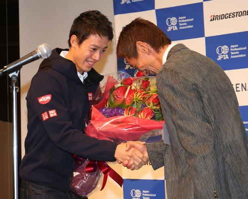 14年11月24日、ジュニア時代のコーチ、柏井さん（右）から花束を受け取り握手を交わす錦織