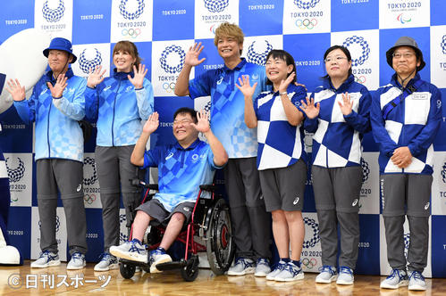 スタッフユニフォームを着て笑顔で手を振る香取慎吾（中央）。右はボランティアユニホーム（撮影・酒井清司）