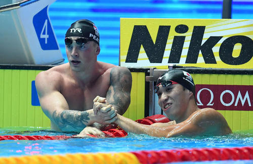 男子00メートル平泳ぎ準決勝で世界新を出したピーティー（左）と握手を交わす小関（撮影・鈴木みどり）