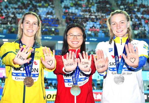 水泳の世界選手権で、闘病中の池江璃花子選手へメッセージを送るショーストロム（右）ら女子100メートルバタフライのメダリストたち（共同）