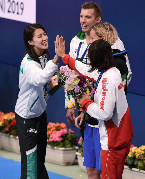 女子200メートル個人メドレーで2位の大橋（左）は、表彰式で女子50メートル平泳ぎ2位の鈴木とハイタッチ（撮影・鈴木みどり）