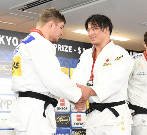 男子90キロ級で2位の向（右）は会見を終え優勝したノエル・ファントエンドと笑顔で握手（撮影・鈴木みどり）