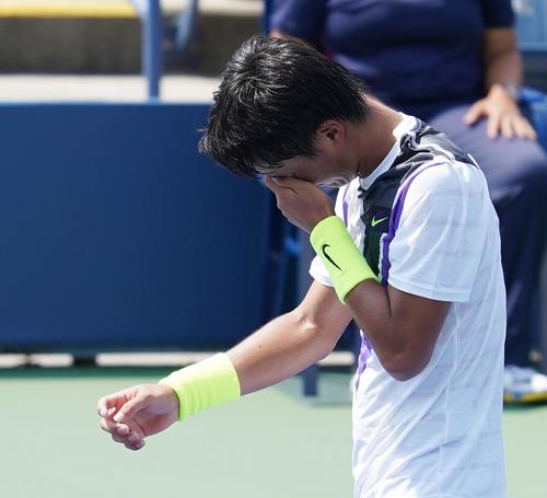 全米オープン・ジュニア男子シングルス2回戦でアレホロレンツォ・リンガラバジェンに敗れ、手で顔を覆う望月（撮影・菅敏）
