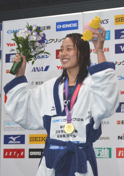 女子100メートル平泳ぎで優勝し、応援席に手を挙げる今井月（撮影・吉池彰）