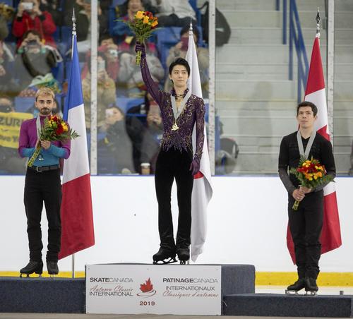 優勝し、表彰台で歓声に応える羽生結弦（中央）（共同）
