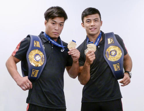 帰国し、金メダルを手にポーズをとる男子グレコローマン60 キロ 級の文田健一郎（右）と同63 キロ 級の太田忍（共同）