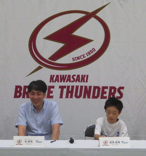 B1川崎の契約書にサインをする高見俊翔君（右）。左は北卓也GM（撮影・松熊洋介）