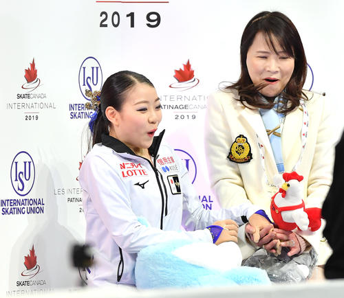 スケートカナダ・女子SPを終え、キスアンドクライで得点を聞き、驚いた表情を見せる紀平。右は濱田コーチ（撮影・菅敏）