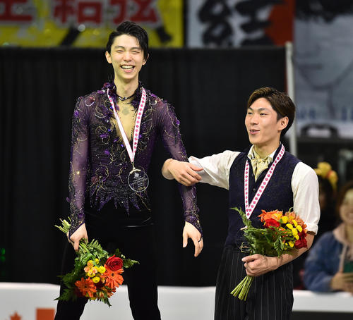 スケートカナダで優勝し、表彰台の上で3位の田中（右）と腕を組み満面の笑みを浮かべる羽生（撮影・菅敏）