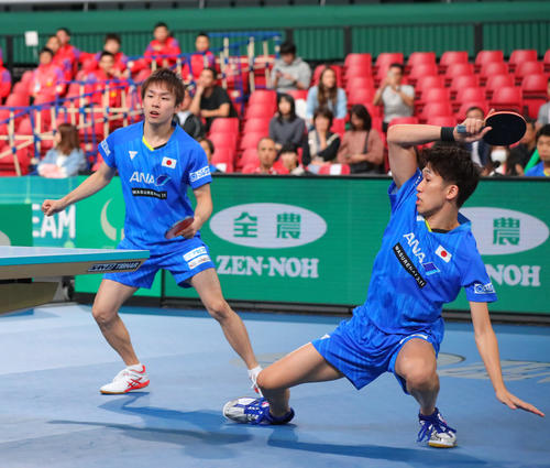 日本対イングランド　第1試合ダブルス、第2セットでドライブを放つ吉村（右）。左は丹羽（撮影・河田真司）