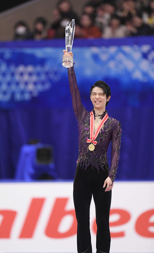 男子シングルスで優勝を決め、表彰式でトロフィーを掲げる羽生（撮影・加藤諒）