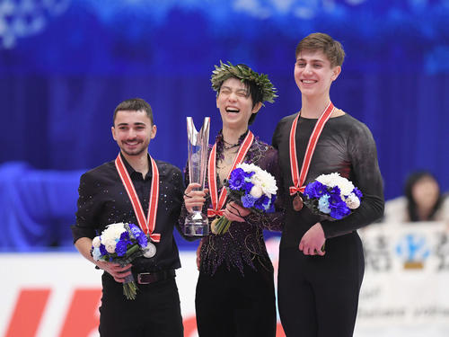 NHK杯　男子シングルスで優勝を決め、表彰式で笑顔を見せる羽生（中央）。左は2位エイモズ、右は3位スドロフスキー（撮影・加藤諒）
