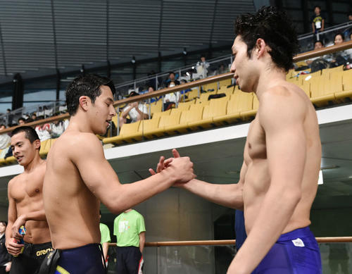 23日、男子400メートル個人メドレーで優勝した瀬戸（手前左）と握手を交わす萩野